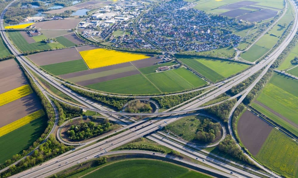 Aerial view of a highway interchange showing roadway design and surrounding land development