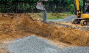 Soil engineer reviewing granular backfill placement at an excavation site before compaction