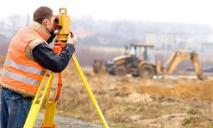 Land surveyor performing construction staking on a Michigan construction site