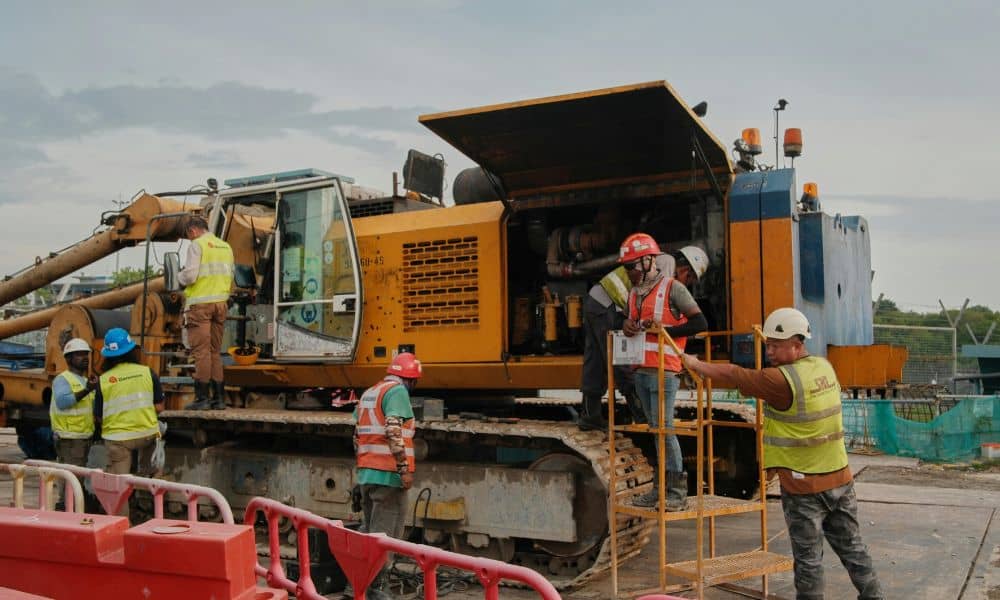 Construction project management team at worksite reviewing heavy equipment during federal shutdown delays