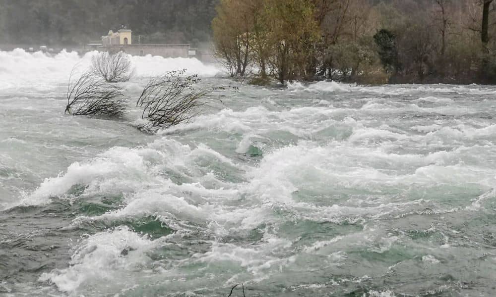 Flooded river with strong water flow highlighting drainage design challenges and stormwater impact