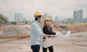 Developers reviewing site plans at a construction site during changes to land entitlements and housing policy