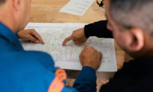 Two professionals reviewing a site plan together during early project planning before submission to an engineering firm