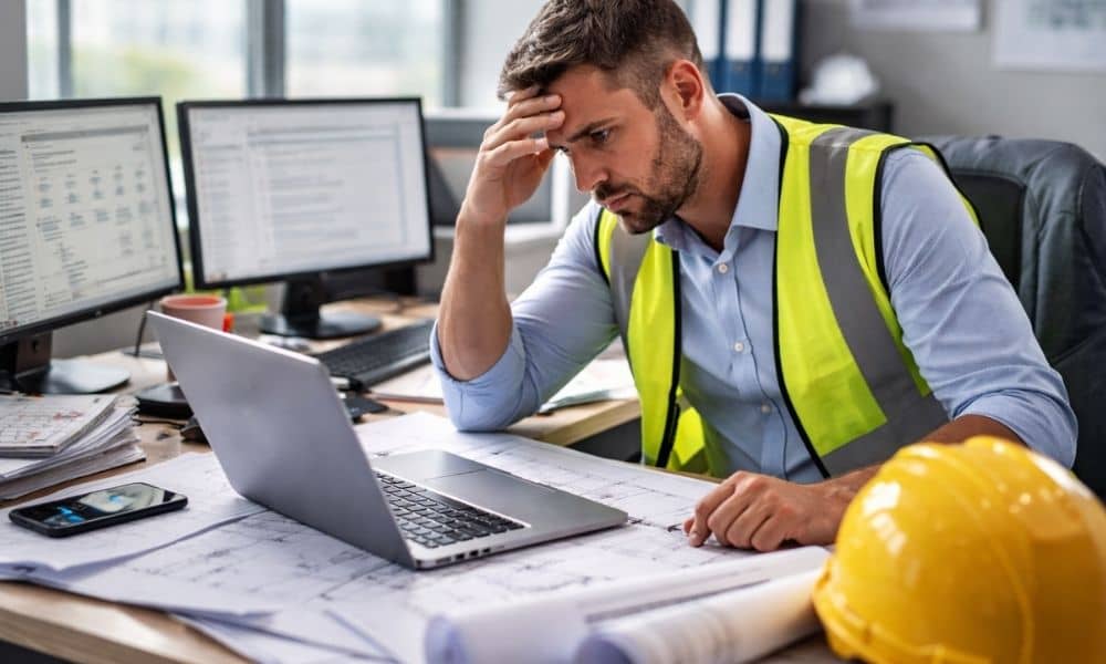 Overloaded project manager desk - ALTA SURVEY Michigan Construction manager overwhelmed with multiple tasks and project approvals causing delays in construction management