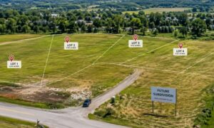 Aerial view of a planned land subdivision showing divided lots and open land near a residential area