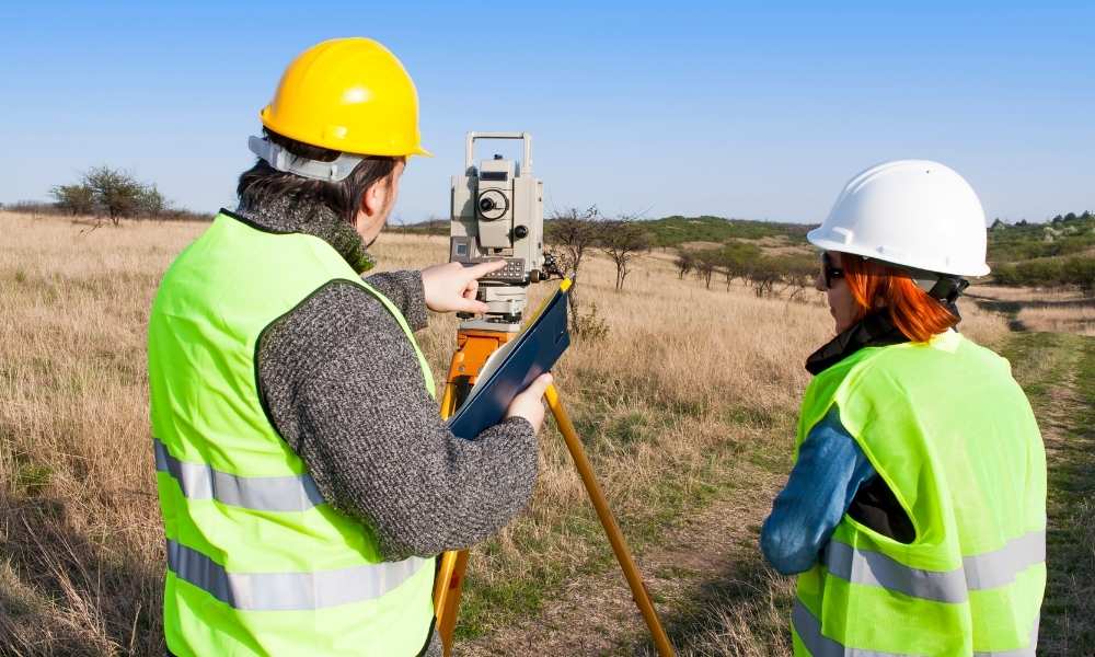 Surveyors conducting land surveys on an undeveloped property before development planning