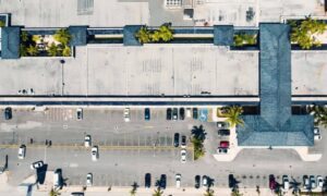 Aerial view of a commercial property showing its building, parking lot, and access areas, highlighting features to consider before signing a lease